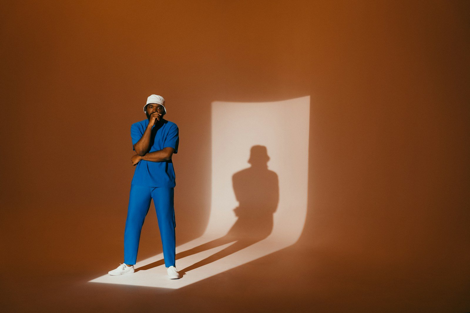 A person poses in front of a shadow.